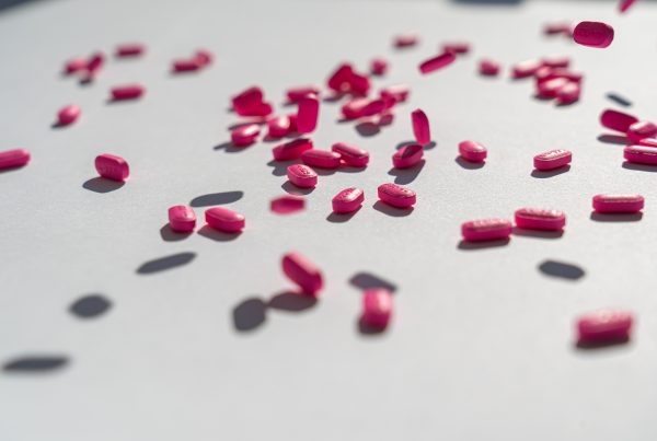 pink pills scattered over a white surface to show anti histamines working for PMS and PMDD